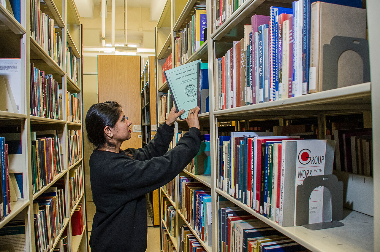 Girl grabbing book from shelf