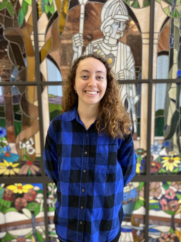 Fiona Hernandez in front of the stained glass Minerva display