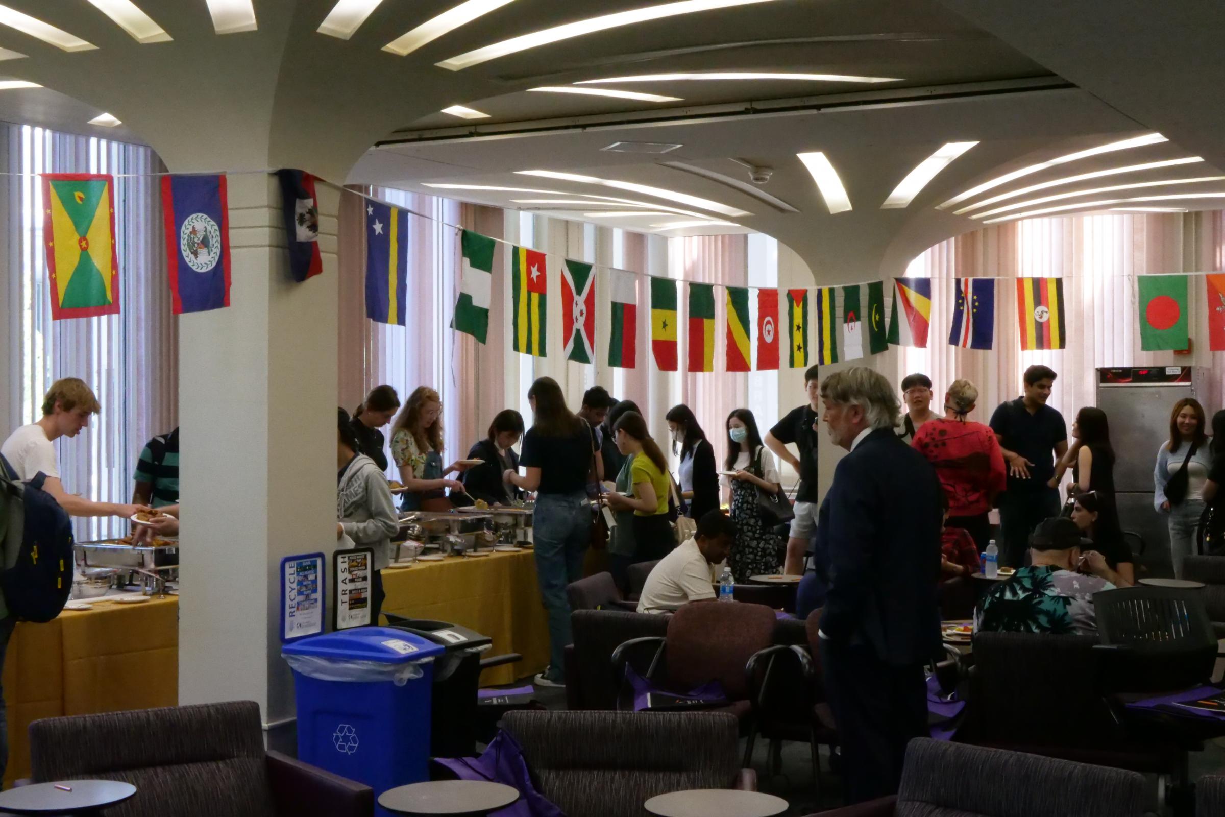 Students lining up for dinner beneath a row of flags