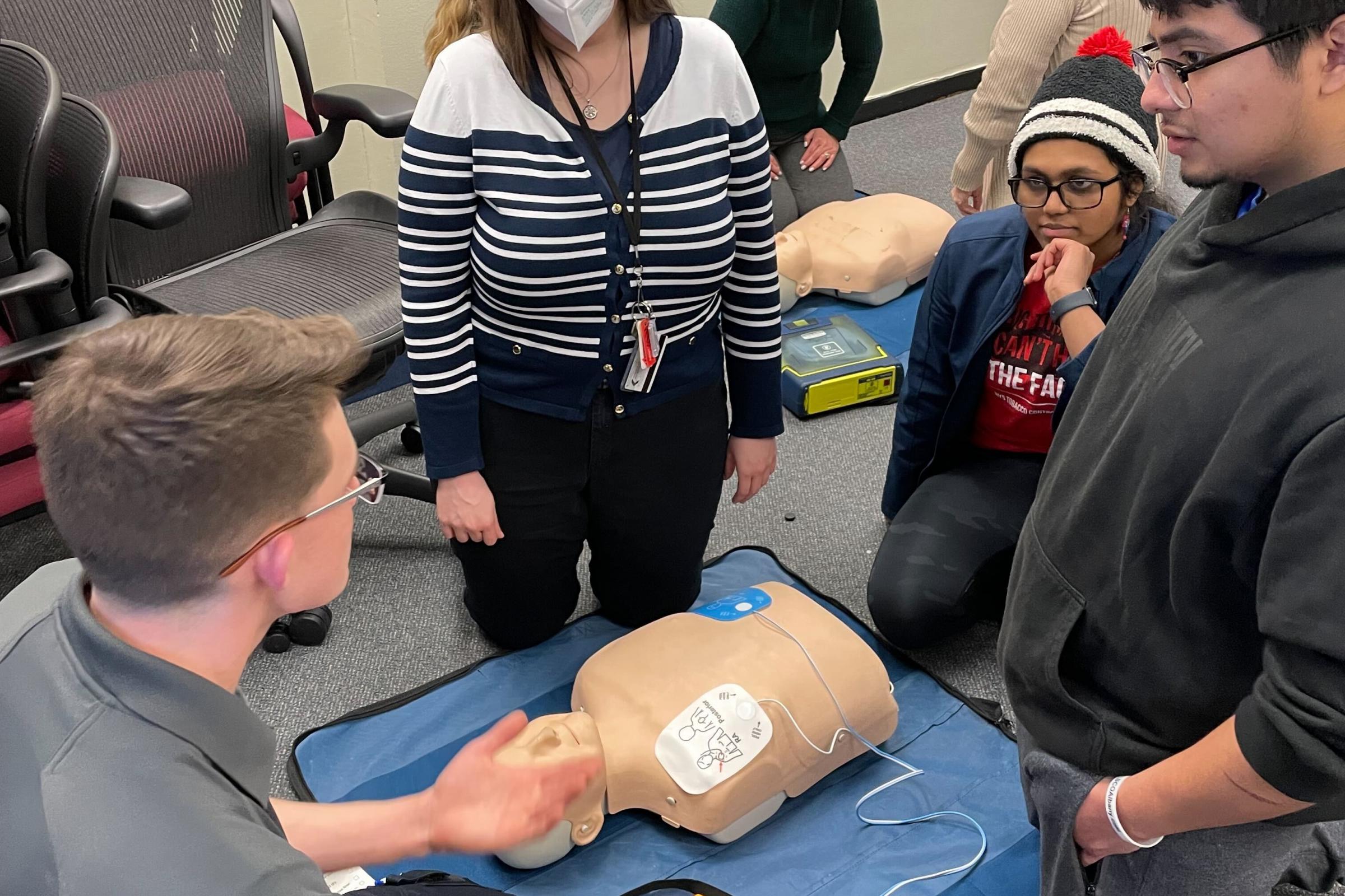 Five Quad volunteer demonstrates how to use an AED