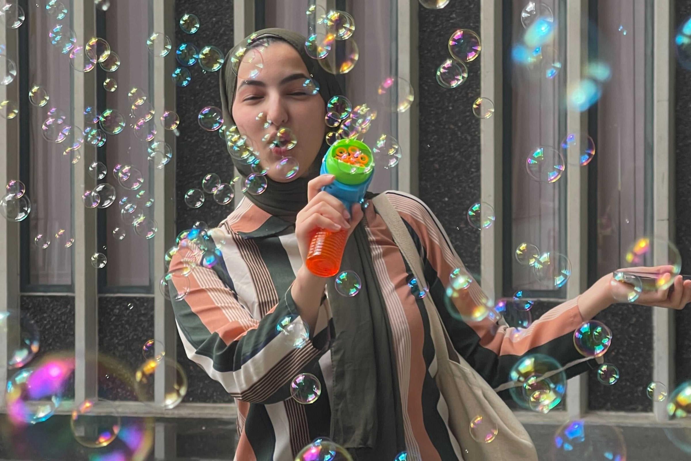 Student blowing bubbles during Stress Less Month